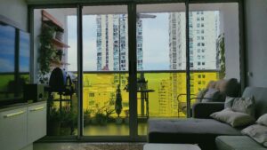 living room with large sliding windows sofa and tv unit