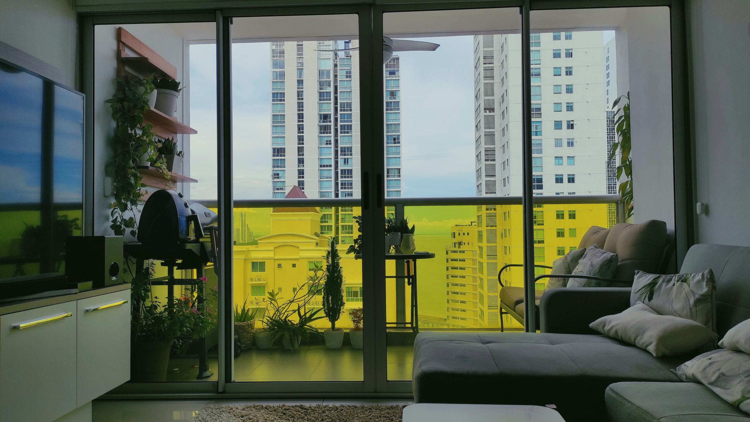 living room with large sliding windows sofa and tv unit