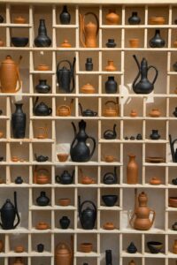 ceramic pots and vases arranged on vertical shelves