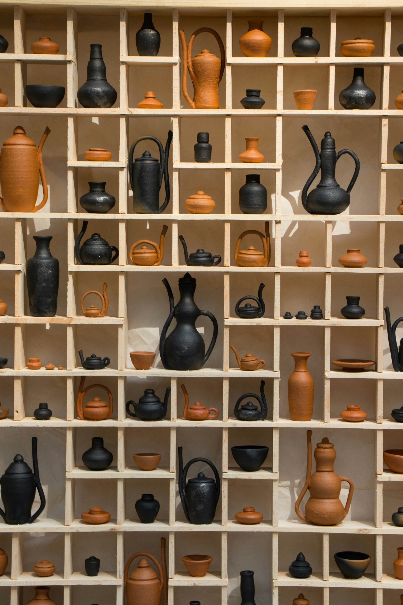 ceramic pots and vases arranged on vertical shelves