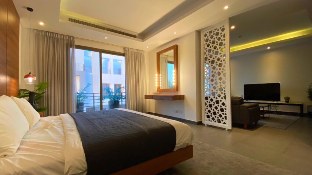 bedroom with double bed, wood partition, large windows, false ceiling and a dresser unit