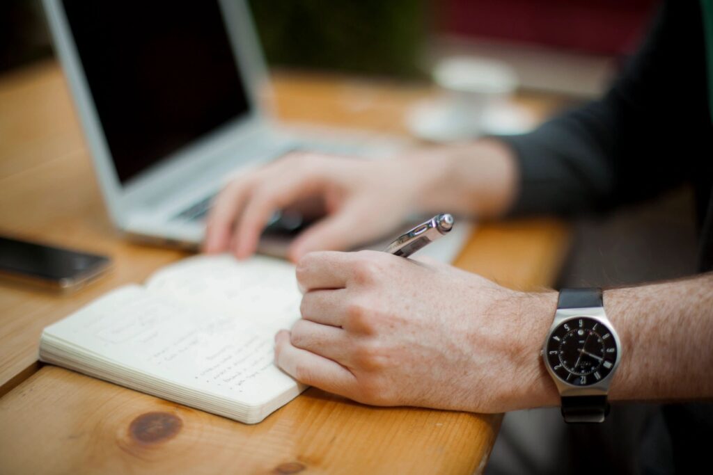 human hand writing with pen on a pad