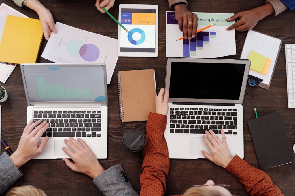 people-sitting-around-a-table-working-on-laptops